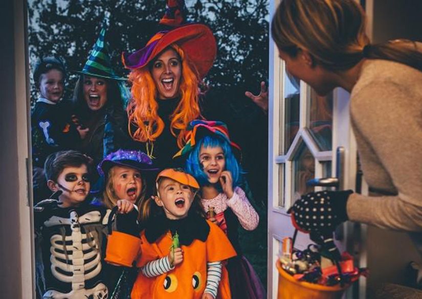 Trẻ em hào hứng trong trò chơi Trick or Treat khi đi gõ cửa và nhận kẹo